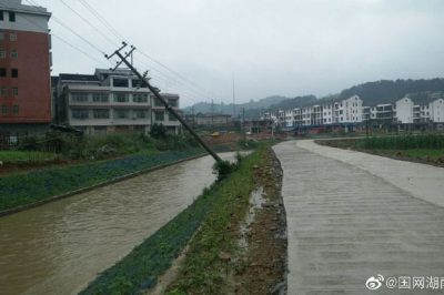武桥供电所组织抢修被暴雨冲刷倾斜电杆