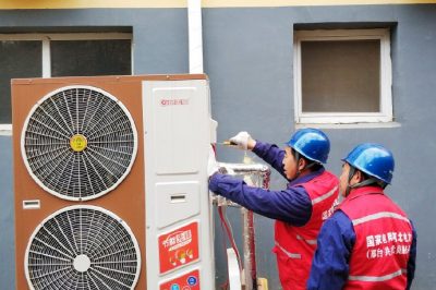 为村民检查供暖设备，确保设备运行正常